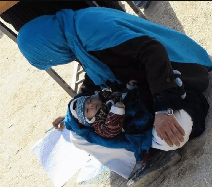 photo Of Afghan Woman Cradling Her Baby While Writing Exam Is Going Viral