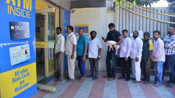 Actor Ravi Babu Spotted Holding A PigletIn A Bank Queue
