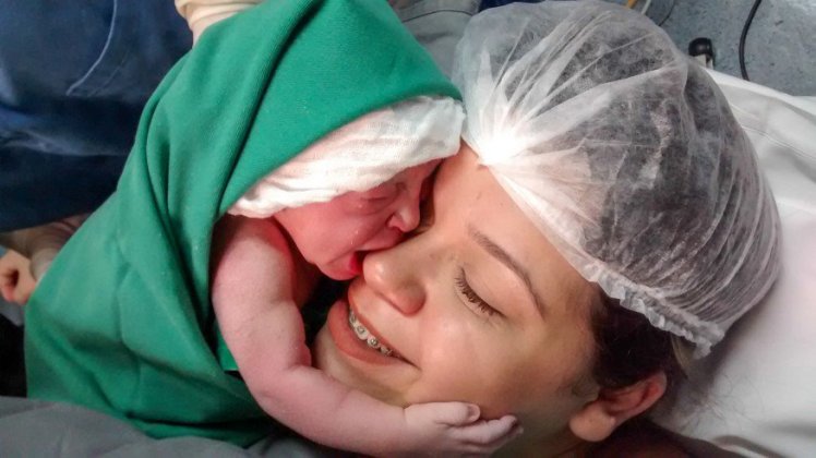 Baby hugs mother moments after birth