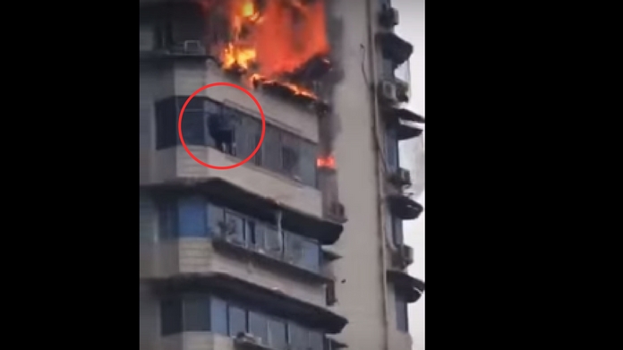 man hangs off building to escape fire