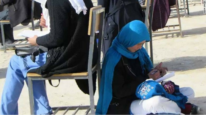photo Of Afghan Woman Cradling Her Baby While Writing Exam Is Going Viral