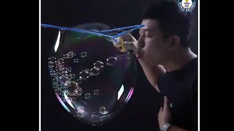 Man blows 783 small bubbles inside a big one