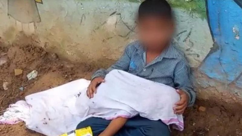 8 years old boy with brother's deadbody wiating for ambulance