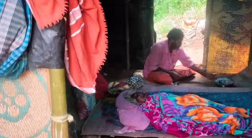 old woman in malakappara adivasi ooru covered in worms