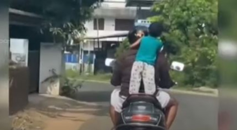 Driving scooter with a two-year-old child standing case against father