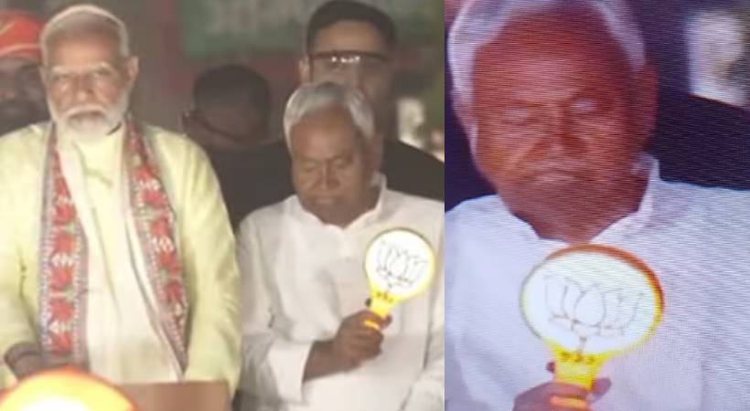 Nitish Kumar holding BJP symbol with Modi at Patna rally